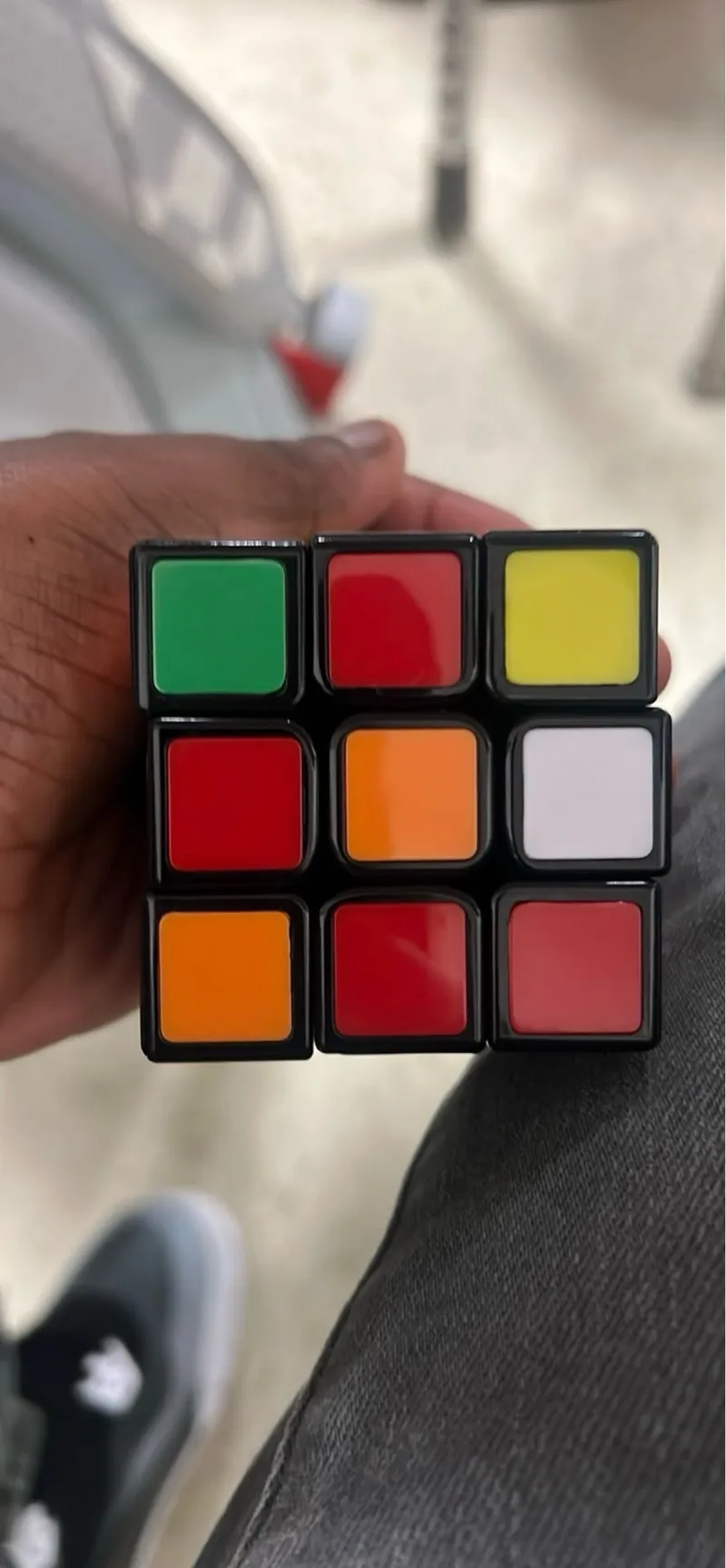  

The image does not contain only text information, input boxes, charts, matrices, or geometry. It shows a physical object - a Rubik's Cube being held in someone's hand. Therefore, there is no relevant text to transcribe using OCR for this image.